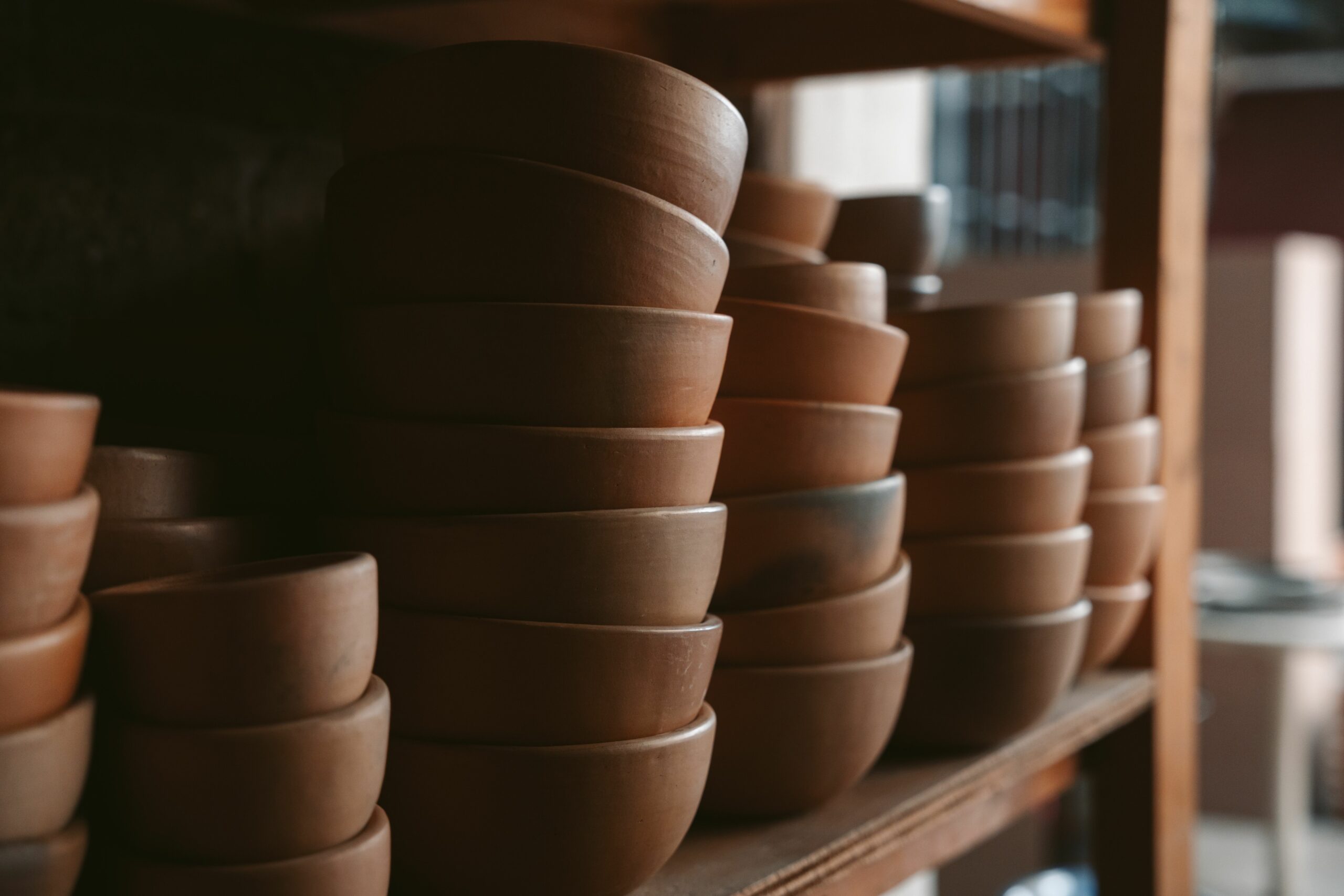 Rustic clay bowls stacked in a traditional Oaxaca workshop, showcasing Mexican craftsmanship.